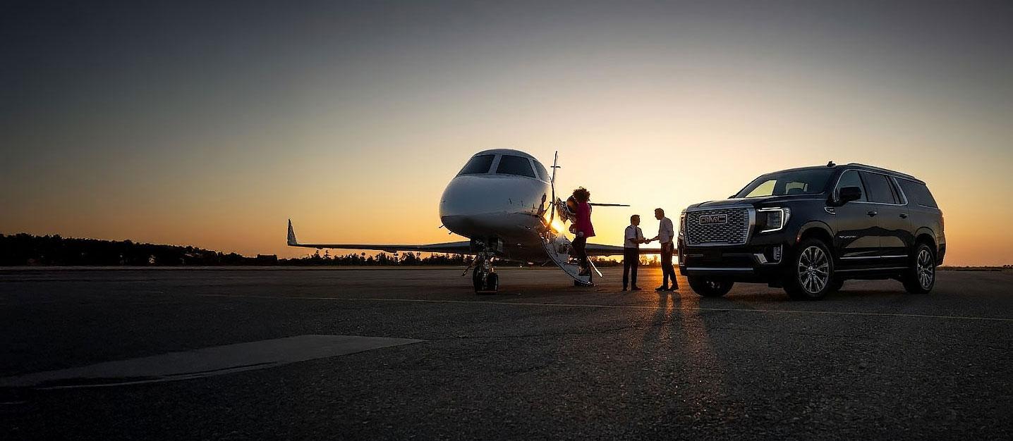 Premium chauffeur service — private jet and black SUV at sunset