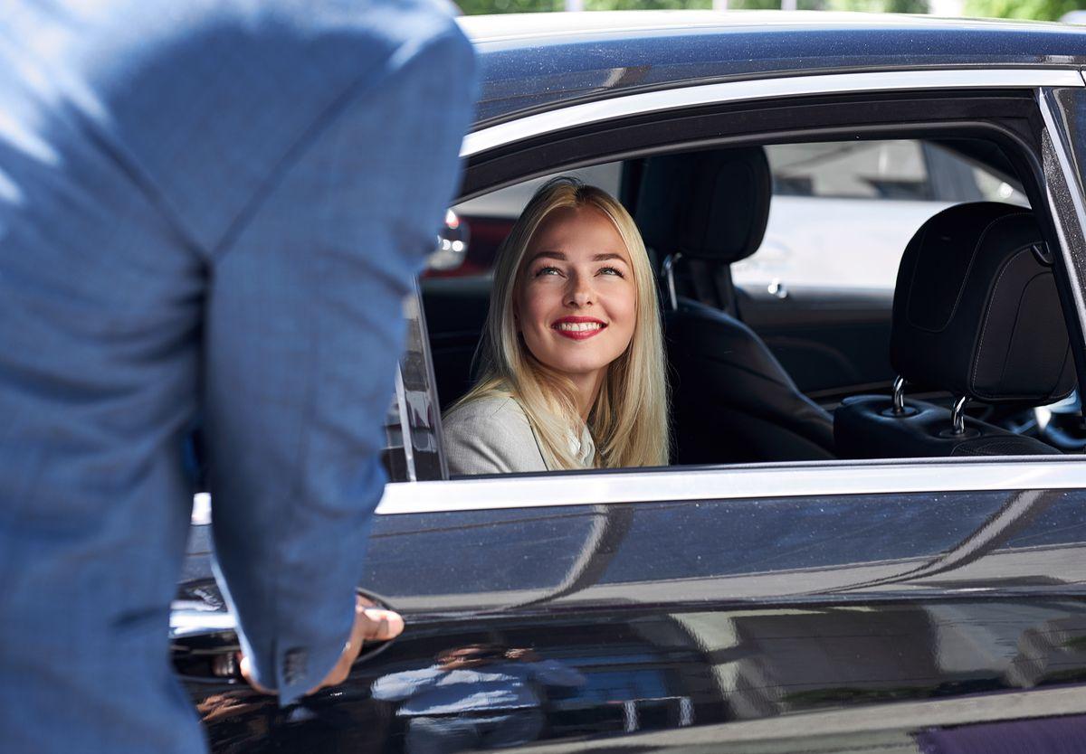Hourly chauffeur service — smiling passenger in black car